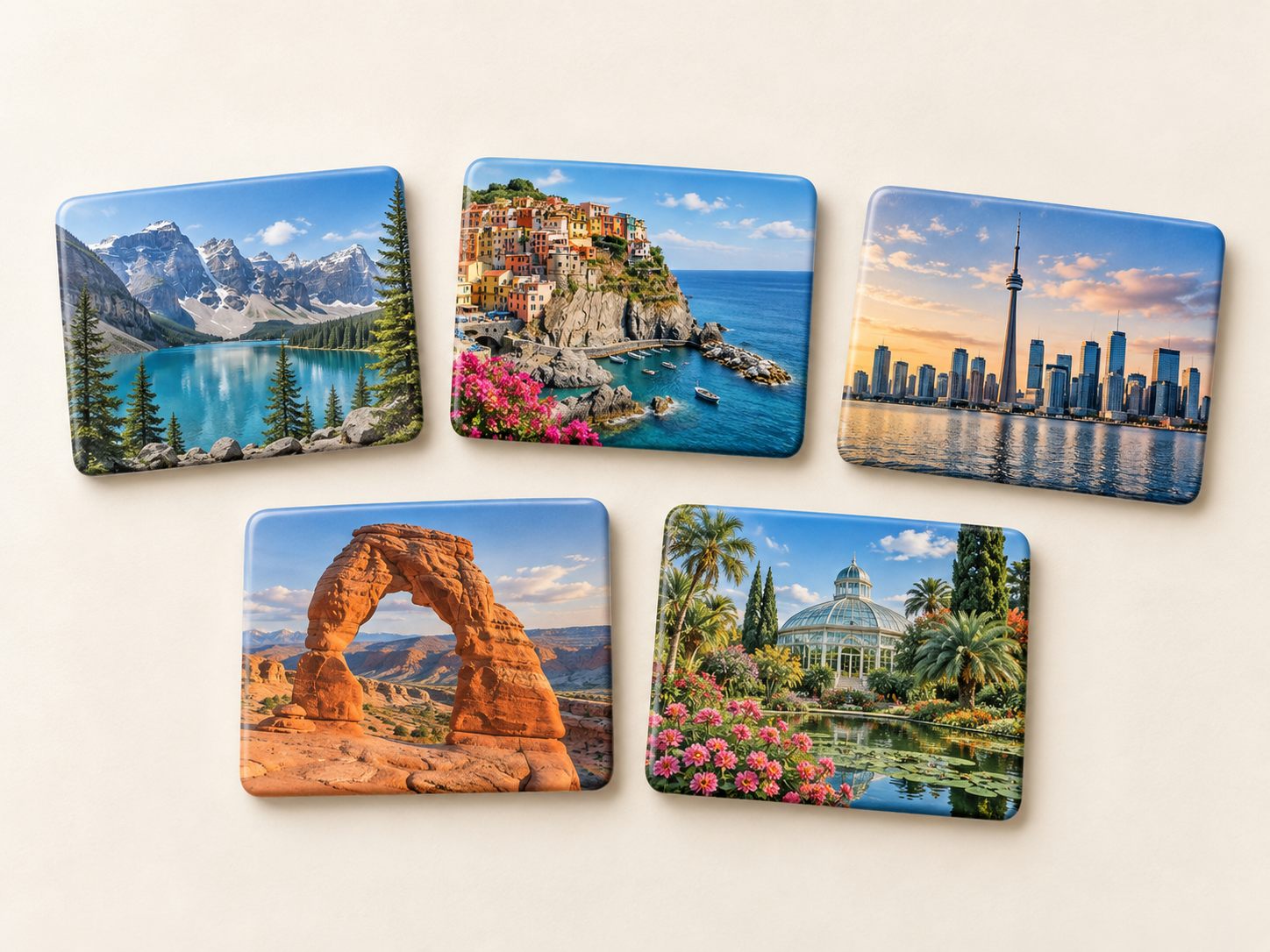 Five printed destination PVC fridge magnets showing scenic travel artwork